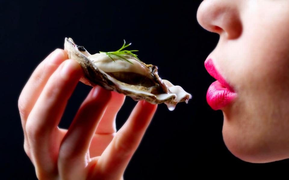 Uma mulher comendo uma ostra